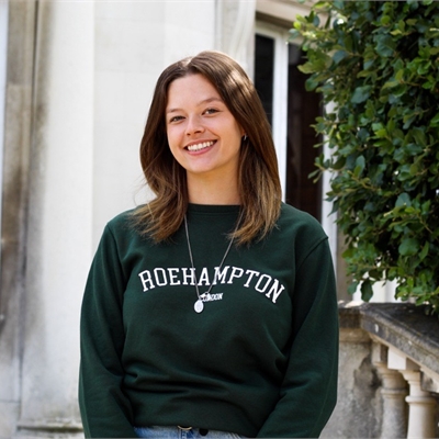 Vice President Education Irene Reynolds is smiling in front of Grove House